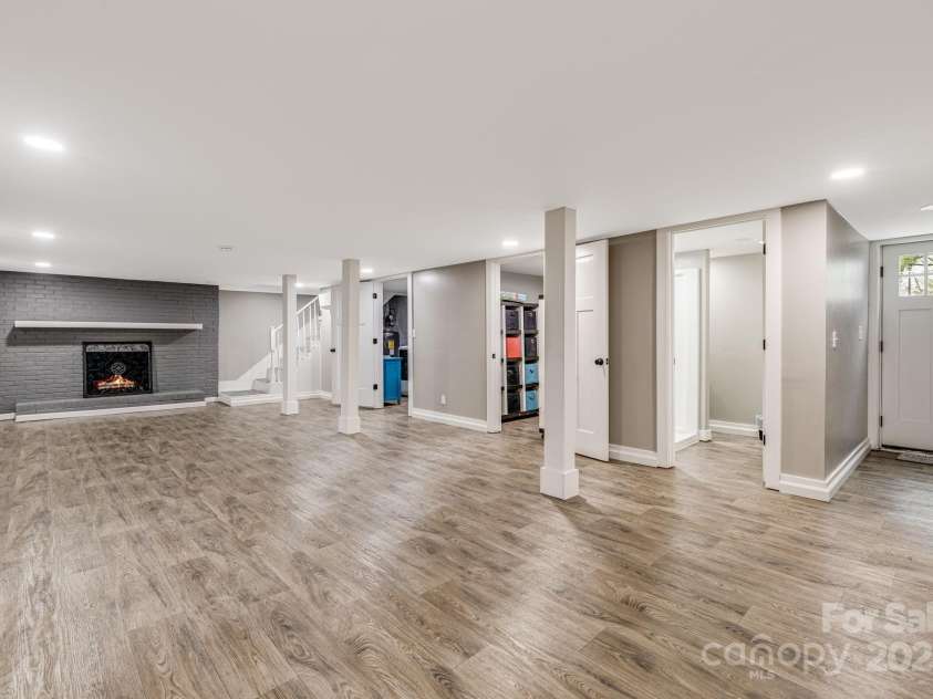 57 Maplewood Knoll Drive, East Flat Rock, NC 28726.  MLS# CAR4239967, YatesRealty ID 6497. Lower level bonus/recreation room with wood burning fireplace, laundry room, storage closet and walkout