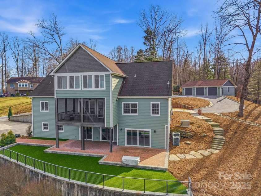 38 Sweetwater Oaks Drive, Fletcher, NC 28732.  MLS# CAR4331629, YatesRealty ID 654. Back of home with turf and view of 3 car detached garage