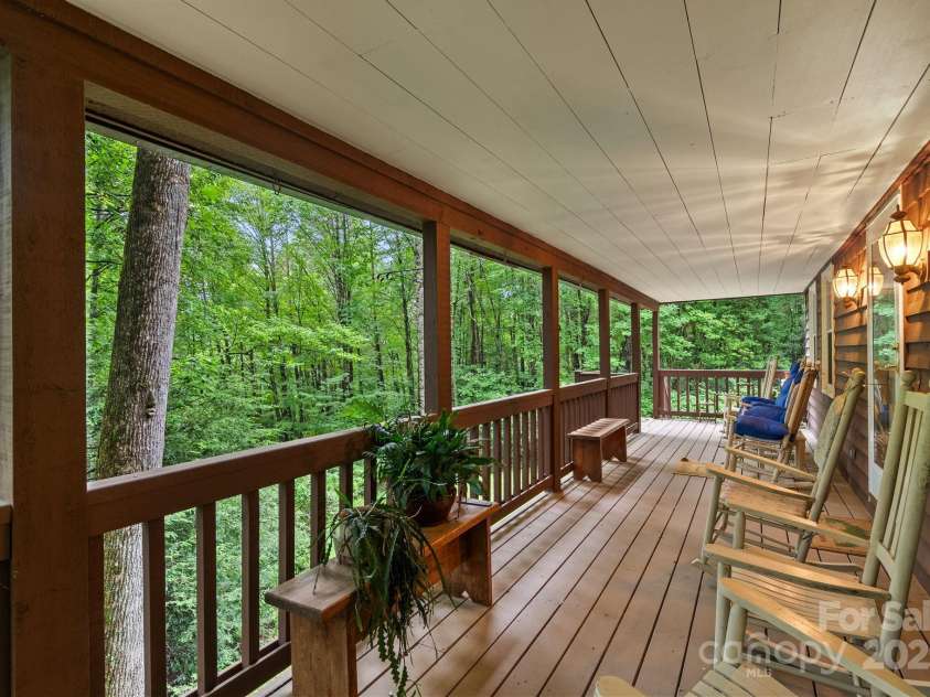 2767 Tanasee Gap Road, Balsam Grove, NC 28708.  MLS# CAR4161160, YatesRealty ID 6567. Front covered rocking chair porch looking to the forest.