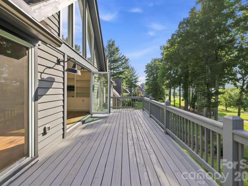 155 Winding Meadows Drive, Flat Rock, NC 28731.  MLS# CAR4418480, YatesRealty ID 6600. The living room flows to a beautiful expansive deck looking out over the golf course