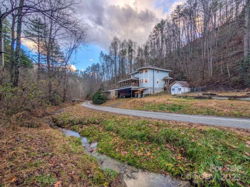 77 Griffith Branch Road, Green Mountain, NC 28740.  MLS# CAR4328405, YatesRealty ID 668. Welcome to 77 Griffith Branch Rd! This two-story home features over +/- 15.5 Acres of wooded untimbered land with covered wrap around porch brimming with potential & ready for someone to bring new life to a once