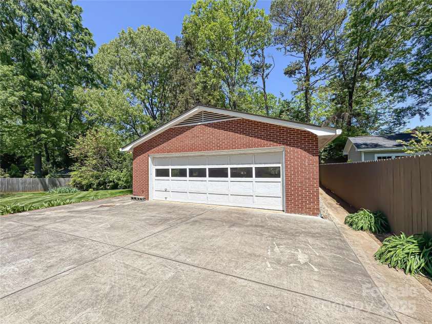 5119 Beckford Drive, Charlotte, NC 28226.  MLS# CAR4247630, YatesRealty ID 6706. An oversized, full brick detached garage provides abundant parking and storage, all set among established, mature trees for added charm and privacy