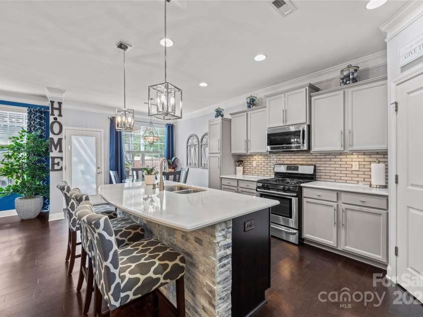 4607 Bonroi Avenue, Charlotte, NC 28213.  MLS# CAR4248280, YatesRealty ID 6713. From the foyer hallway captures this view into the kitchen.  An extra tall pantry with pull out shelves and upscale backslpash added to give this open kitchen a top designer feel.  Notice the custom stone accent lining t