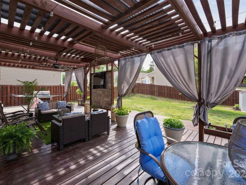 4607 Bonroi Avenue, Charlotte, NC 28213.  MLS# CAR4248280, YatesRealty ID 6713. Pergola allows sunlight in but creates comfort for hanging out outside.  Check out the custom stone TV mount as the central focus of the outdoor living area.