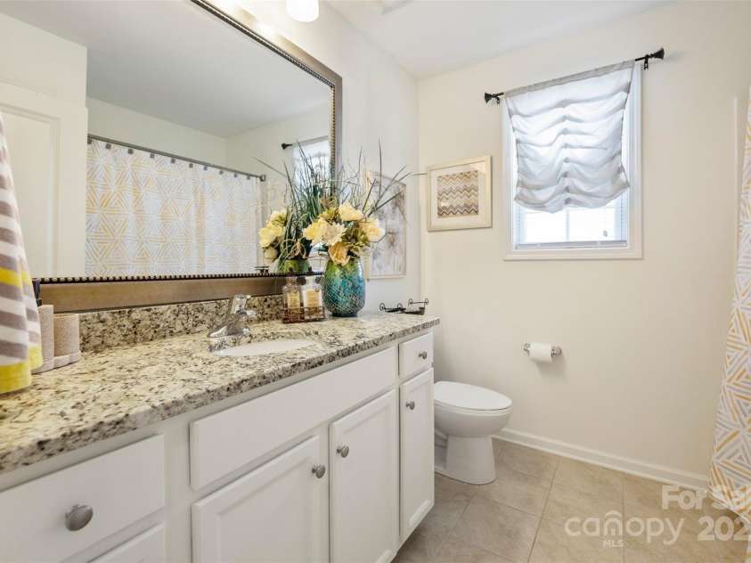 4607 Bonroi Avenue, Charlotte, NC 28213.  MLS# CAR4248280, YatesRealty ID 6713. This is bathroom #3 and it is located between bedroom #4 and #5.  It has beautiful granite counter tops and nice tile flooring.  The large vanity has plenty of space with large mirror above.