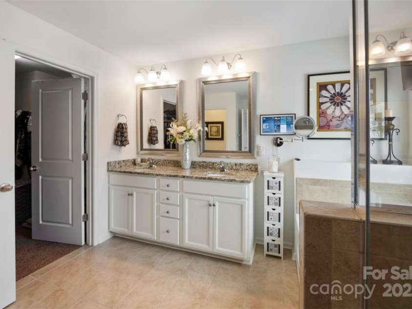 4607 Bonroi Avenue, Charlotte, NC 28213.  MLS# CAR4248280, YatesRealty ID 6713. Walking in from the primary suite, the large frameless glass shower is to the right , beside the shower is the garden tub, double vanity with granite counter tops and large walk in closet to the left