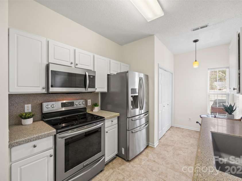 8830 Cinnabay Drive, Charlotte, NC 28216.  MLS# CAR4227249, YatesRealty ID 6758. Kitchen with quartz counters, tile floor and stainless appliances