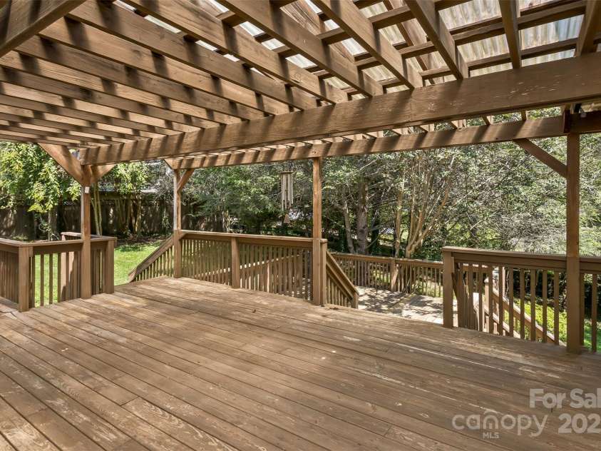 15 Beaverdam Knoll Road, Asheville, NC 28804.  MLS# CAR4283730, YatesRealty ID 684. The covered deck is very large and provides access to the gallery deck off the sunroom and the lower deck that leads to the back yard. Out of view to the left is a stainless steel natural gas grill.