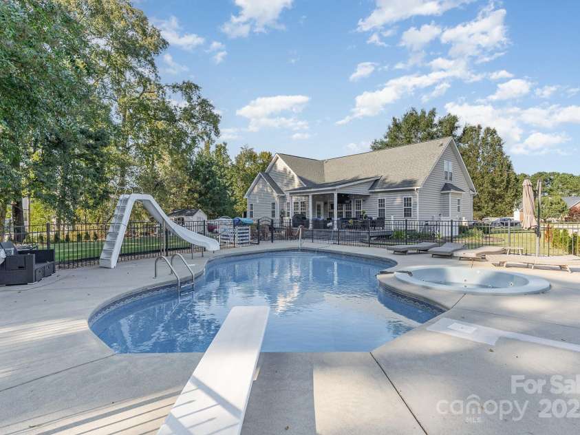9404 Perimeter Court, Zebulon, NC 27597.  MLS# CAR4191333, YatesRealty ID 6842. Dive into fun with this fenced saltwater pool and hot tub combo, complete with a slide and diving board.