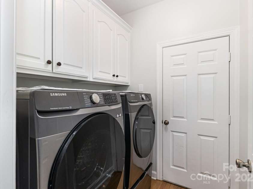 9404 Perimeter Court, Zebulon, NC 27597.  MLS# CAR4191333, YatesRealty ID 6842. The laundry area accommodates a large washer and dryer, complete with overhead storage cabinets to help keep the space organized and tidy.