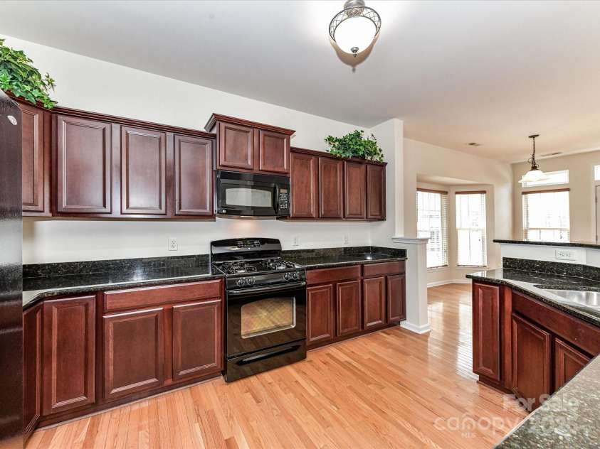 7518 Turley Ridge Lane, Charlotte, NC 28273.  MLS# CAR4272341, YatesRealty ID 688. Dark kitchen cabinets and open space to the living room