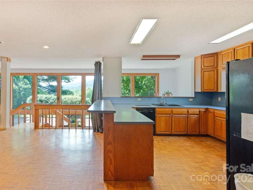 556 Blue Hill Road, Marshall, NC 28753.  MLS# CAR4154163, YatesRealty ID 6887. Large kitchen opens into main living area and lower level sunroom