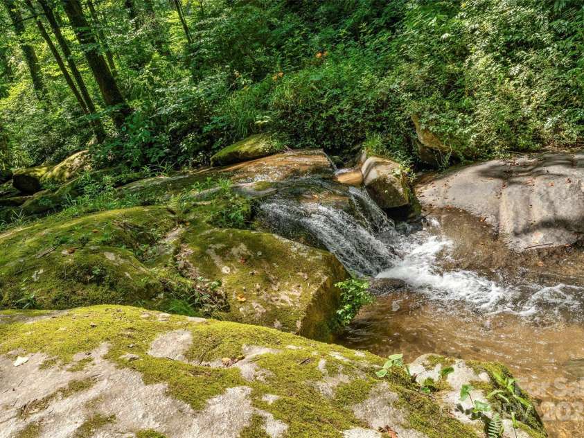 240+ and 252 General Hill Road, Flat Rock, NC 28731.  MLS# CAR4234844, YatesRealty ID 6906. Serene water tumbling over rocks on Beck Creek, which passes through the property on its way to the Green River.