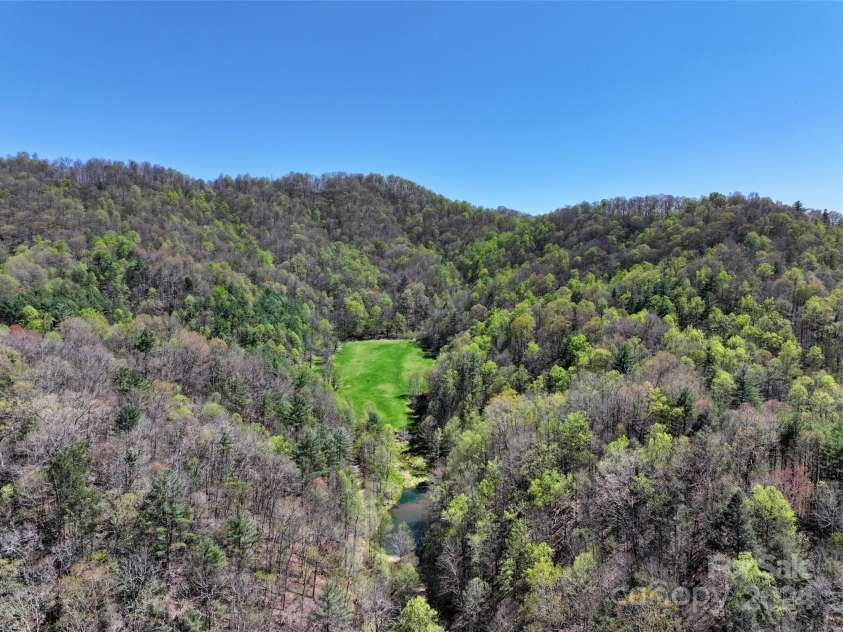 2180 Pigeon Roost Road, Green Mountain, NC 28740.  MLS# CAR4137054, YatesRealty ID 693. Aerial of hidden meadow surrounded by unspoiled ridges