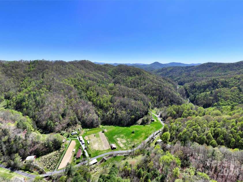 2180 Pigeon Roost Road, Green Mountain, NC 28740.  MLS# CAR4137054, YatesRealty ID 693. Aerial of the large flat pasture with old apple tree in center -- just add horses!  Also has small barn on perimeter