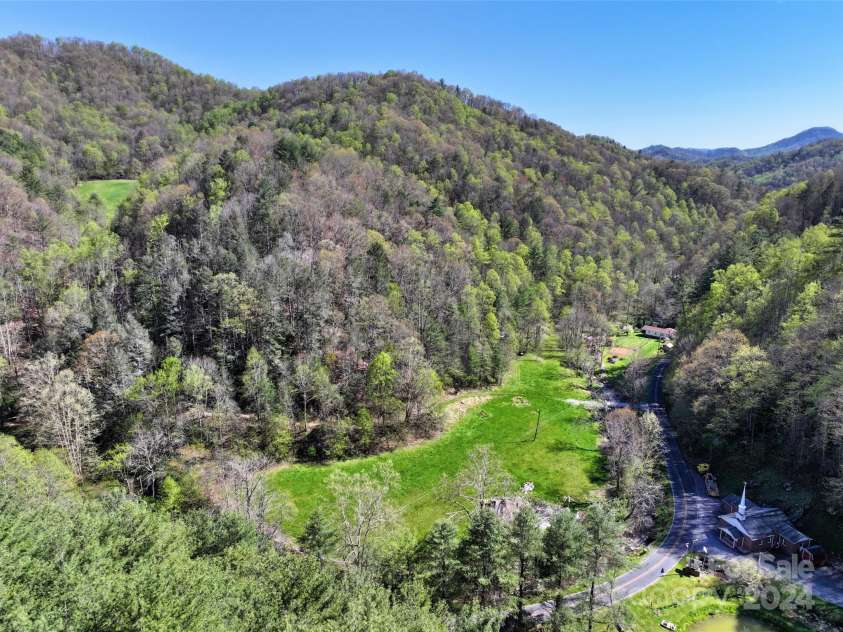 2180 Pigeon Roost Road, Green Mountain, NC 28740.  MLS# CAR4137054, YatesRealty ID 693. Another flat pasture with fertile soil, bordered by Pigeon Roost Creek