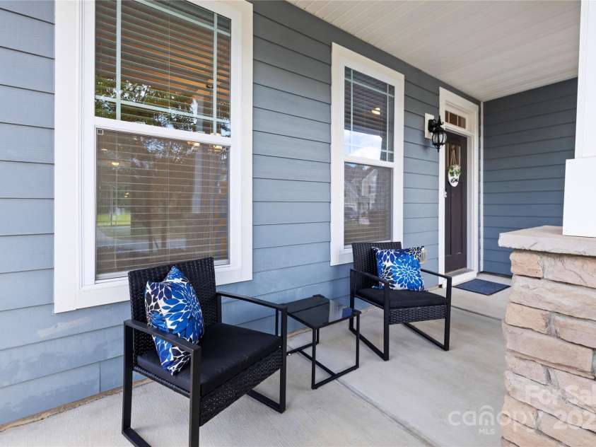3023 Spinner Court, Denver, NC 28037.  MLS# CAR4142435, YatesRealty ID 6943. Enjoying a leisurely moment on the front porch, immersing oneself in the serene ambiance of the neighborhood.