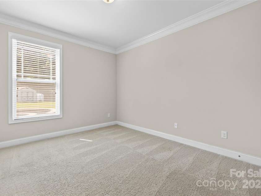 3023 Spinner Court, Denver, NC 28037.  MLS# CAR4142435, YatesRealty ID 6943. Guest bedroom located on the main floor boasts a full ensuite bath, offering privacy and comfort for visitors, ensuring they feel right at home during their stay.