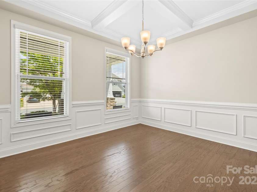 3023 Spinner Court, Denver, NC 28037.  MLS# CAR4142435, YatesRealty ID 6943. The formal dining room exudes elegance with coffered ceilings and picture frame molding, offering a perfect blend of classic charm and modern grace.