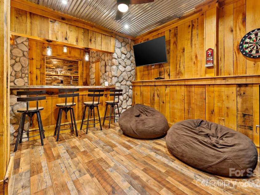 501 Bolt Road, Lake Lure, NC 28746.  MLS# CAR4241628, YatesRealty ID 6962. Lower-level custom bar and TV area