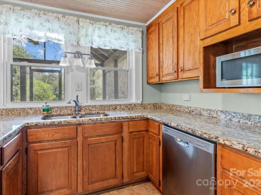 10633 Hwy 52 Highway, Rockwell, NC 28138.  MLS# CAR4233308, YatesRealty ID 6979. Remodeled kitchen with granite counters, oak cabinets, bead board ceiling, stainless appliances, and the double bowl sink overlooks screened in porch. Stand alone Microwave will convey.
