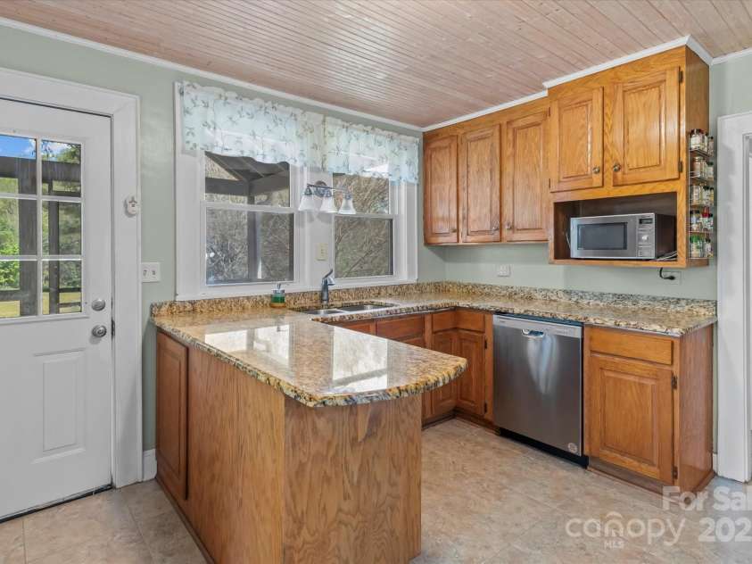 10633 Hwy 52 Highway, Rockwell, NC 28138.  MLS# CAR4233308, YatesRealty ID 6979. Remodeled kitchen with granite counters, stainless appliances, double bowl sink overlooks screened in porch.
