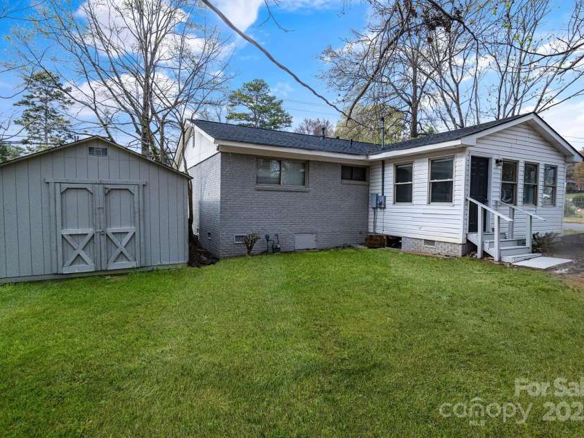 2801 Alleghany Street, Charlotte, NC 28208.  MLS# CAR4239718, YatesRealty ID 7009. Rear of home showing backyard with storage shed.