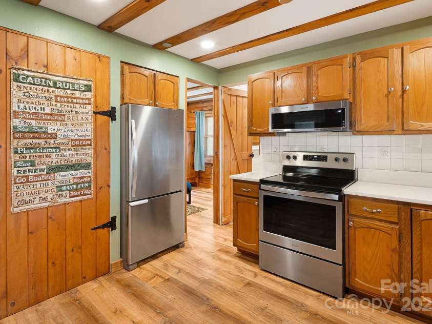 2977 Heath Peak Road, Waynesville, NC 28785.  MLS# CAR4247346, YatesRealty ID 7029. Kitchen with brand new countertops and flooring leading into primary bedroom