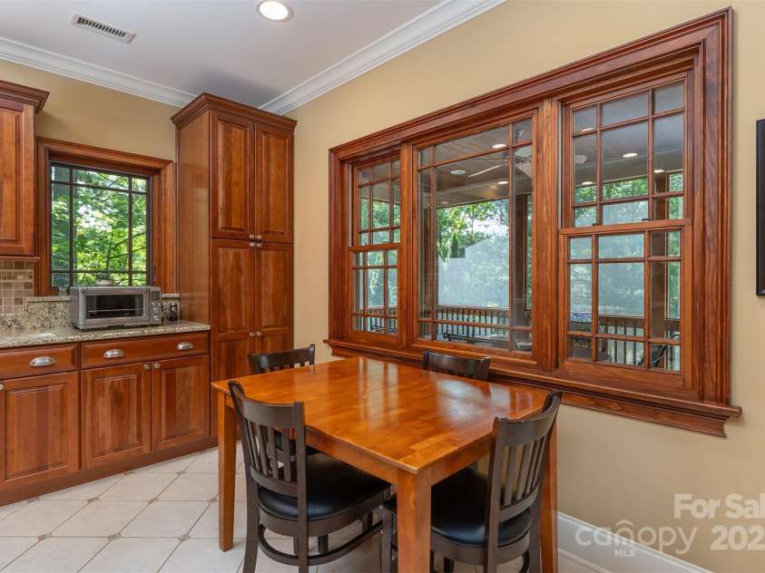 168 Chattooga Run, Hendersonville, NC 28739.  MLS# CAR4250934, YatesRealty ID 706. Cozy kitchen table with a peaceful view of the 200 sq ft screened-in porch.