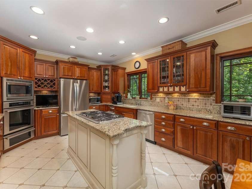 168 Chattooga Run, Hendersonville, NC 28739.  MLS# CAR4250934, YatesRealty ID 706. Stylish tile granite and a high-performance gas cooktop with downdraft make this kitchen a chef’s dream.