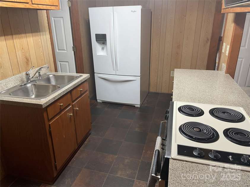 1300 Irish Potato Road, Concord, NC 28025.  MLS# CAR4244013, YatesRealty ID 7225. Kitchen/Laundry downstair - refrigerator remains.