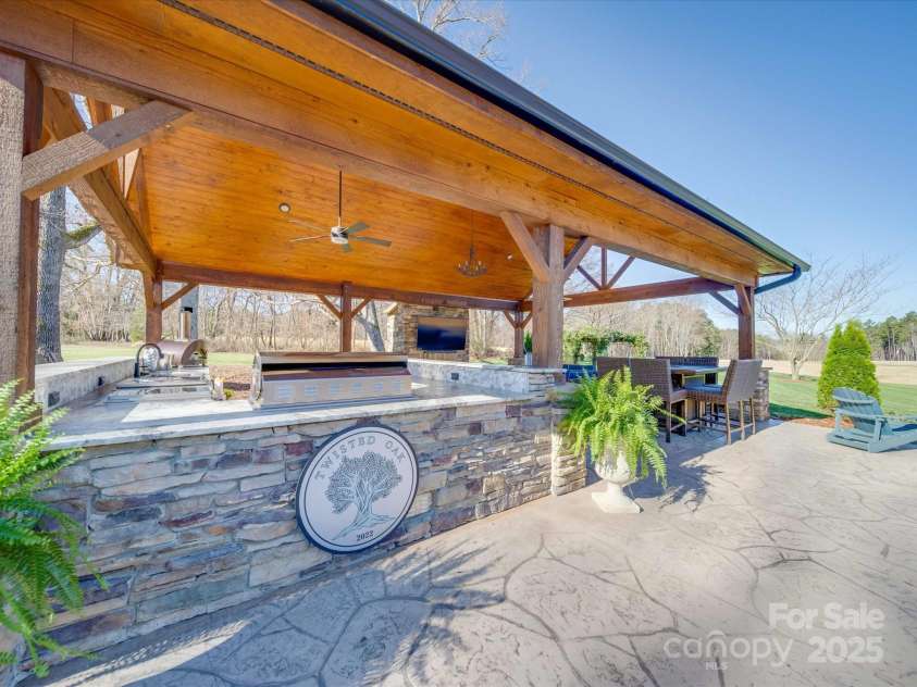 810 Lake Wright Road, China Grove, NC 28023.  MLS# CAR4236007, YatesRealty ID 7274. Pavilion showcasing outdoor kitchen with fireplace and sitting area next to Saltwater Pool