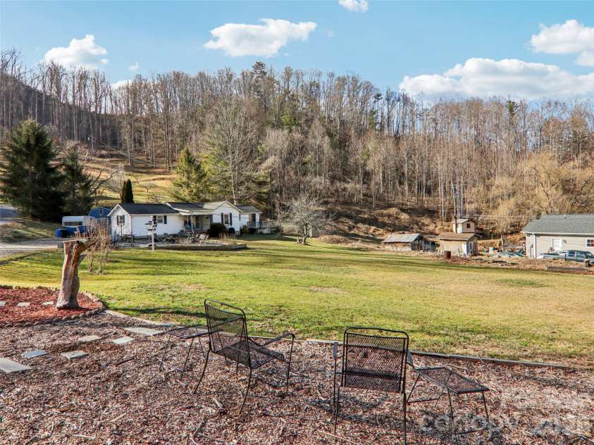 7 Landon Mountain Lane, Weaverville, NC 28787.  MLS# CAR4334252, YatesRealty ID 7316. Expansive, gently sloping front yard with usable open space, mature trees, and a peaceful rural setting, offering views across the property toward the home and surrounding wooded hillsides.