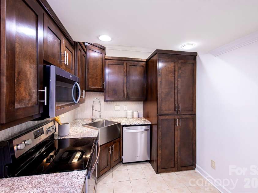 939 Linda Lane, Charlotte, NC 28211.  MLS# CAR4360605, YatesRealty ID 7408. Full sized stack washer/dryer in basement behind cabinet doors
