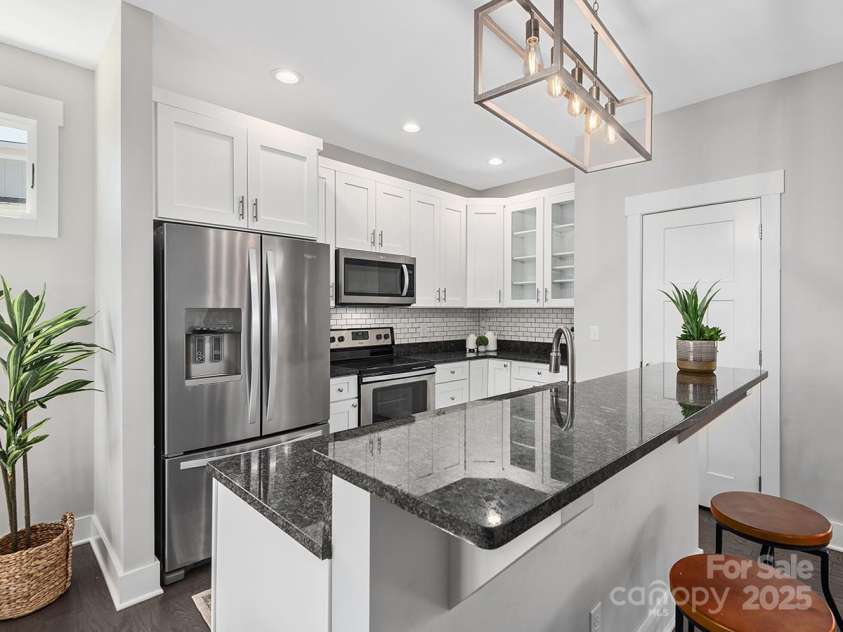 34 Walnut Lane, Asheville, NC 28804.  MLS# CAR4233293, YatesRealty ID 7421. Dream modern kitchen with stainless steel appliances, multi-level islands, tile backsplash and large cabinets for storage