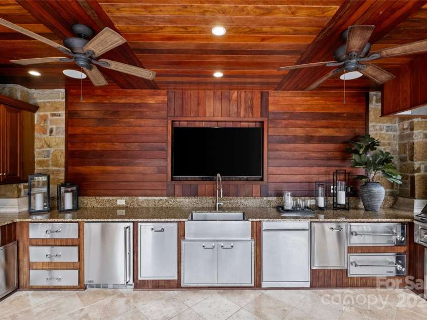 4536 Fox Brook Lane, Charlotte, NC 28211.  MLS# CAR4157549, YatesRealty ID 7532. Cabana with outdoor Kitchen and entertainment center with custom cabinetry and Lynx appliances.Ice machine, 50” built-in gas grill and sauté station with hood systemwarming drawer, dishwasher, beverage refrigerator.