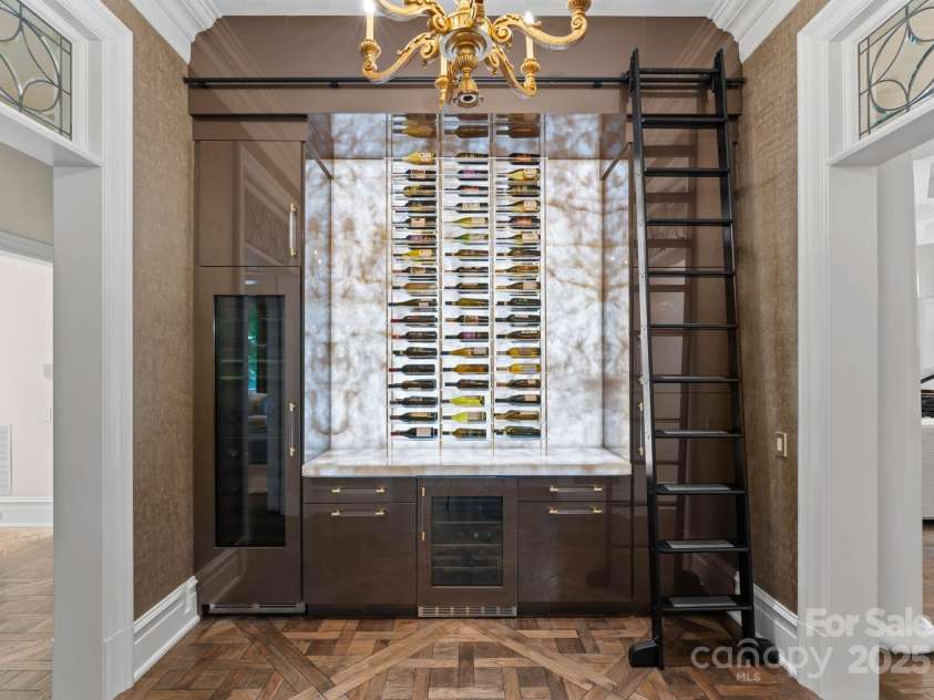 4536 Fox Brook Lane, Charlotte, NC 28211.  MLS# CAR4157549, YatesRealty ID 7532. Custom butlers pantry with transitional wine closet and rack system with custom backlight.Cristallo quartzite countertops