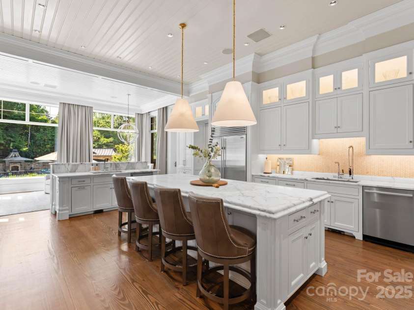 4536 Fox Brook Lane, Charlotte, NC 28211.  MLS# CAR4157549, YatesRealty ID 7532. Dual island design opens to additional dining and seating space with; fireplace overlooking the backyard and pool area.