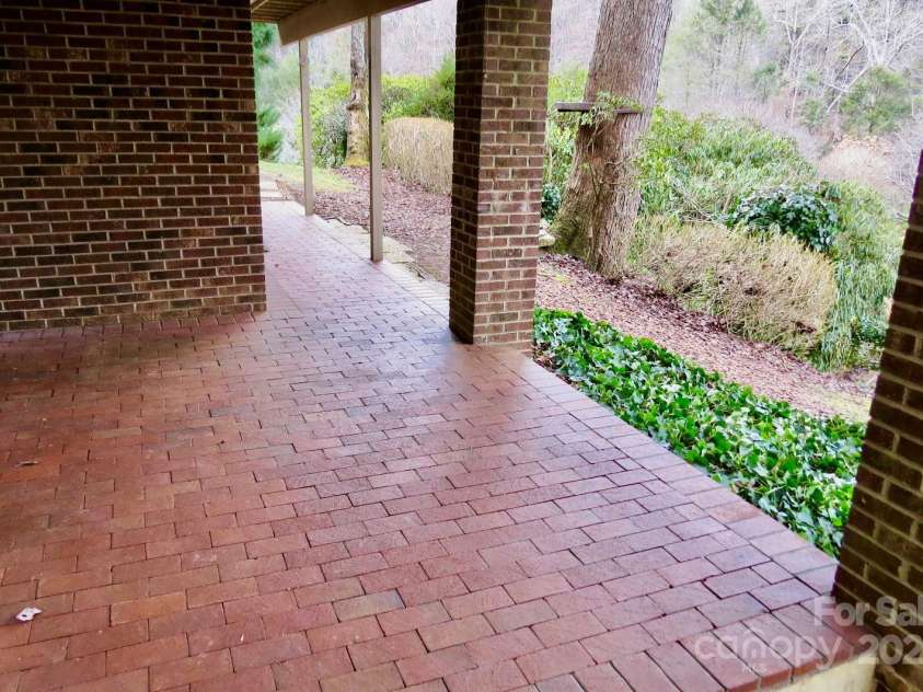 871 Glen Cannon Drive, Pisgah Forest, NC 28768.  MLS# CAR4216993, YatesRealty ID 7558. Brick patio outside basement rooms