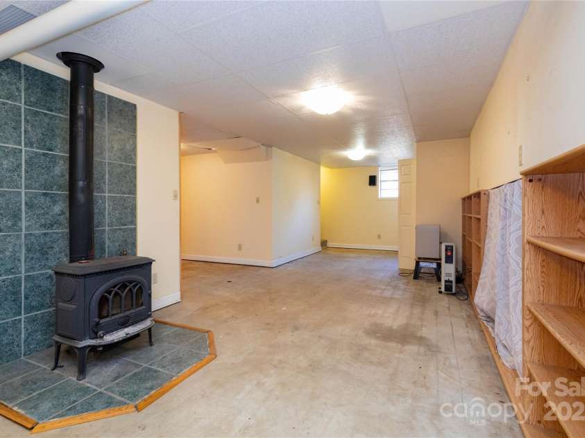 61 Bull Mountain Road, Asheville, NC 28805.  MLS# CAR4216001, YatesRealty ID 7664. Basement flex space, Jotul wood stove.