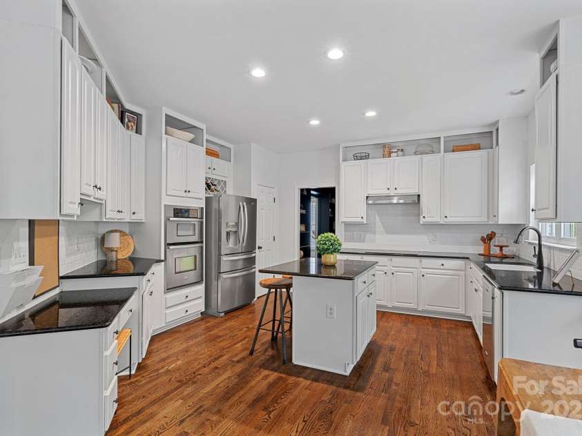 8600 Glade Court, Huntersville, NC 28078.  MLS# CAR4246992, YatesRealty ID 7694. The large kitchen has granite counters, a center island with seating, a command center and wall oven/microwave.  Custom trim added above cabinetry!