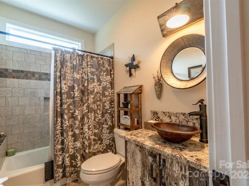 1519 Triplett Road, Cleveland, NC 27013.  MLS# CAR4218302, YatesRealty ID 7715. Lovely Hall Bathroom With Custom Barnwood Vanity and Tiled Tub Surround!  Check Out The Unique Barnwood Light, Basin, and Circular Mirror; As Well As The Bronze Vanity Handle Hardware And Single Lever Faucet.