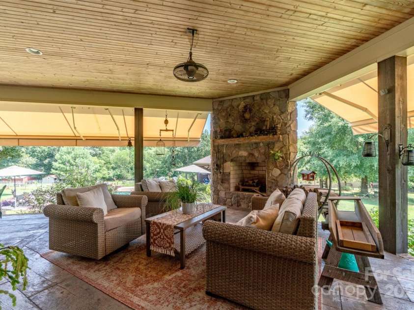 1519 Triplett Road, Cleveland, NC 27013.  MLS# CAR4218302, YatesRealty ID 7715. Or How About Relaxing In The Awesome Covered Outdoor Living Area With Beadboard Ceiling, Stone Fireplace and Stamped Concrete Barnwood-look Floors