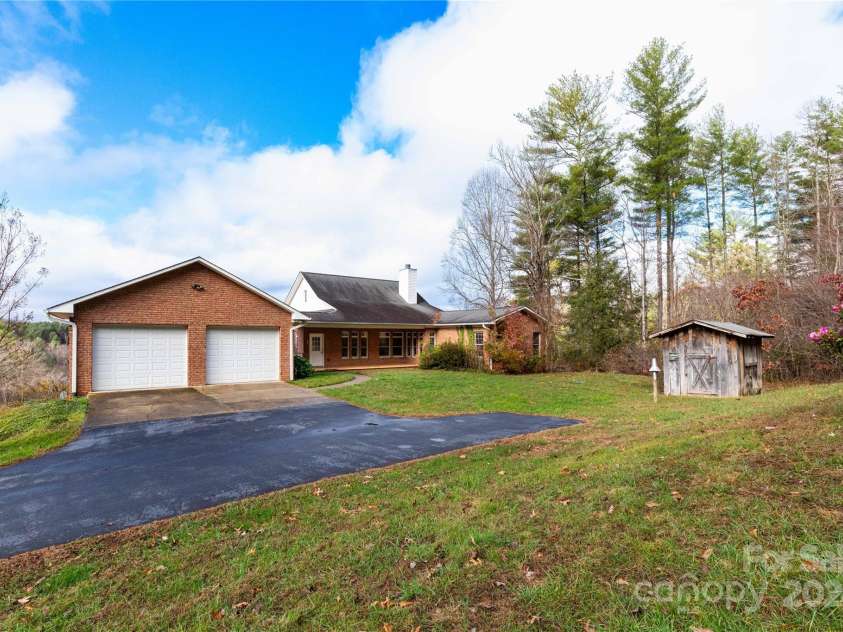 1025 Upper Brush Creek Road, Fairview, NC 28730.  MLS# CAR4195772, YatesRealty ID 7723. Back of home with detached two car garage and outbuilding.