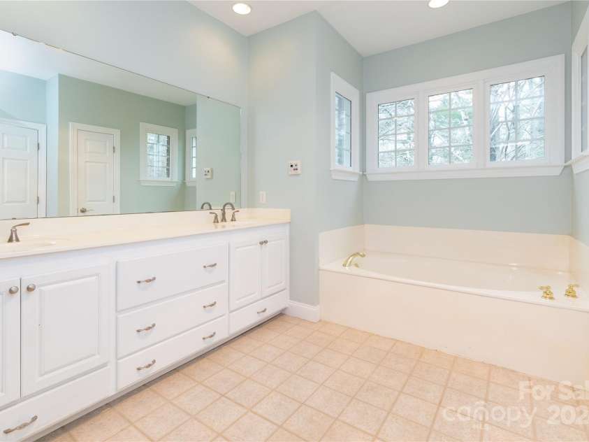 1025 Upper Brush Creek Road, Fairview, NC 28730.  MLS# CAR4195772, YatesRealty ID 7723. Primary bathroom with double vanity, stand up shower and soaker tub.