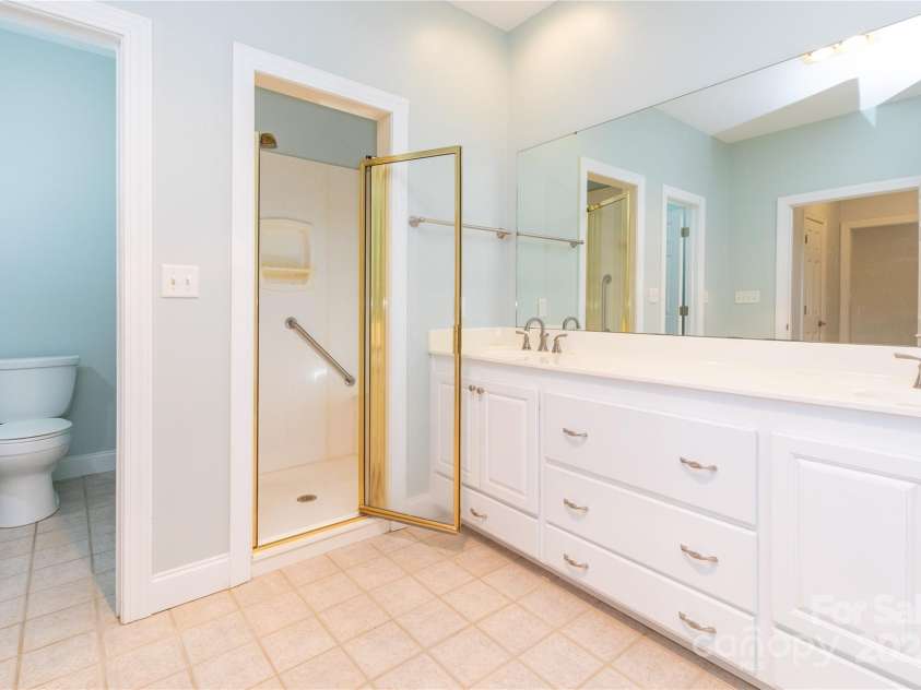 1025 Upper Brush Creek Road, Fairview, NC 28730.  MLS# CAR4195772, YatesRealty ID 7723. Primary bathroom with double vanity, stand up shower, soaker tub and private toilet area.