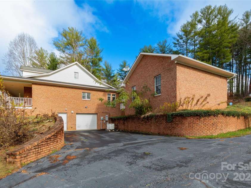 1025 Upper Brush Creek Road, Fairview, NC 28730.  MLS# CAR4195772, YatesRealty ID 7723. Side of home with two car basement garage.