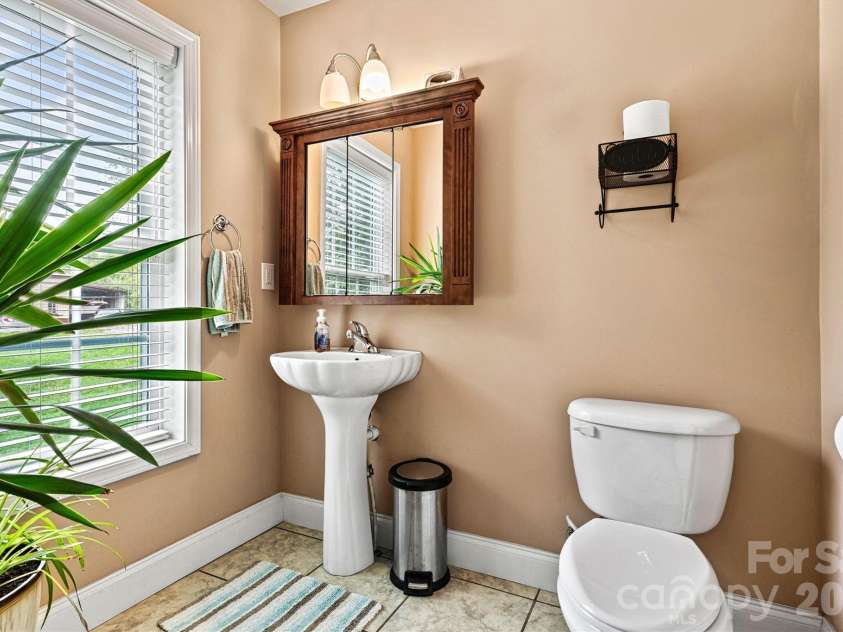 6051 Pointe West Lane, Vale, NC 28168.  MLS# CAR4357030, YatesRealty ID 7760. Half bath ensuite, located in downstairs Primary suite