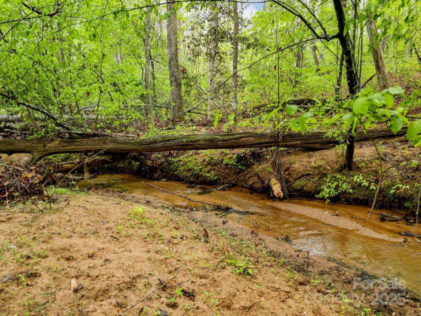 241 Pinefield Drive, Tryon, NC 28782.  MLS# CAR4250675, YatesRealty ID 7781. Beautiful creek