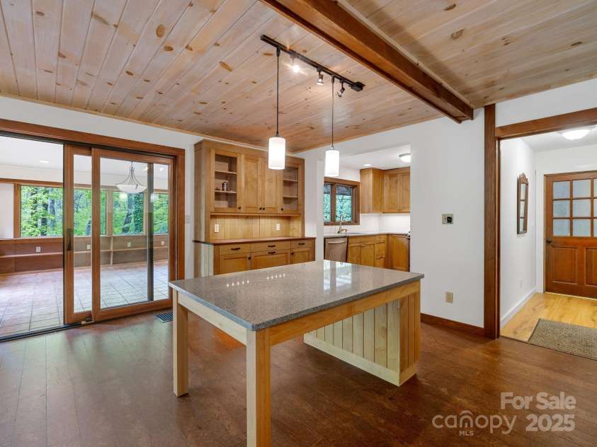 241 Pinefield Drive, Tryon, NC 28782.  MLS# CAR4250675, YatesRealty ID 7781. Dining island. Door to the right leads to the mud room and garage. Kitchen through the middle doorway. Sliding glass door leads to the sunroom.